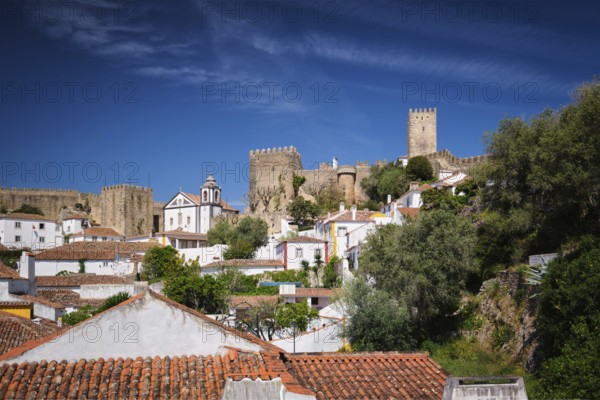 Obidos castle stands proudly above the old houses, showcasing Portugal's rich history and scenic views in this picturesque town