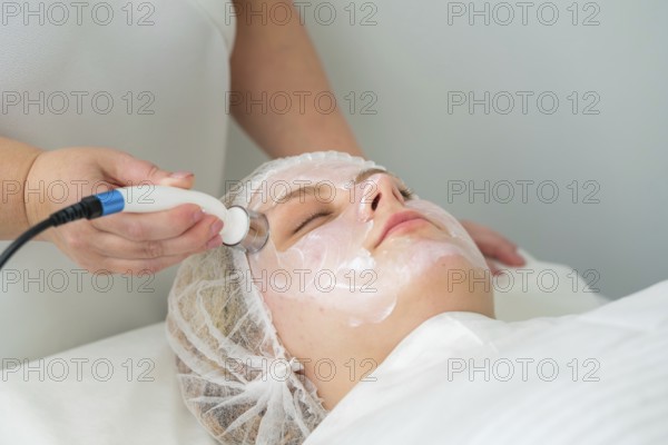 Client relaxes as a specialist applies a metallic applicator during RF lifting, promoting skin tightening and collagen production