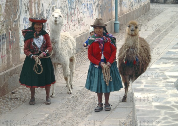 Traditionally dressed woman with llamas and small children in Cusco, Peru, Andean Highlands, South America, September 1997, vintage, retro, old, historic