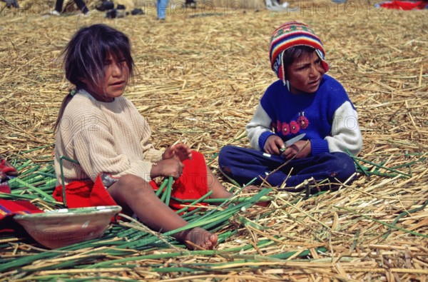 Children sitting on a floating Uro island in Lake Titcaca, Peru, South America, September 1997, vintage, retro, old, historic