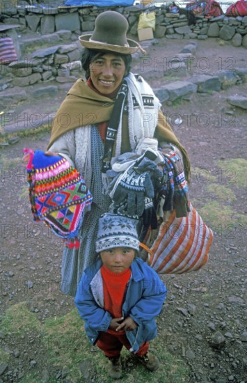 A woman with a small child sells souvenirs to tourists at the Sillustani ruins on Lake Umayo near Puno, Andean highlands, Peru, South America, September 1997, vintage, retro, old, historic