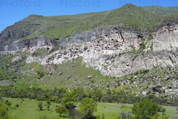 A rocky cliff with numerous caves carved into the rock face, cave town, cave monastery, Kura River, Vardzia, Samtskhe—Javakheti region, Samtske Javacheti, Lesser Caucasus, Georgia