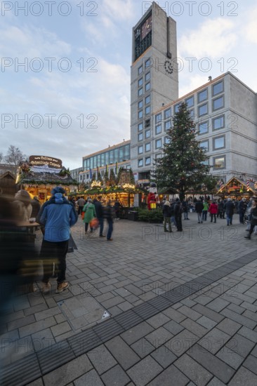 The Christmas market on the market square, in front of Stuttgart City Hall 2025, shines in festive lights in the evening. Many people visit the stands and enjoy the Christmas atmosphere