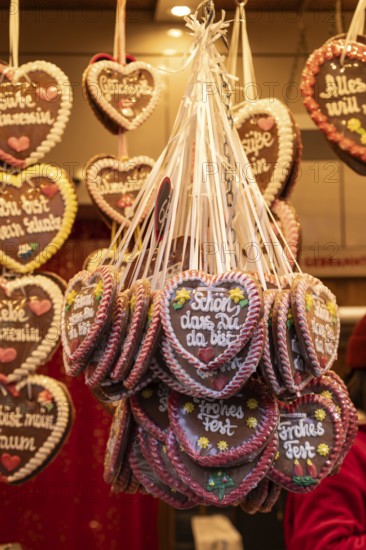 Colourful gingerbread hearts hang on the festive stands at the Stuttgart Christmas market. They are a popular sweet treat and embody the Christmas atmosphere. The selection is large and invites you to feast and give as a gift