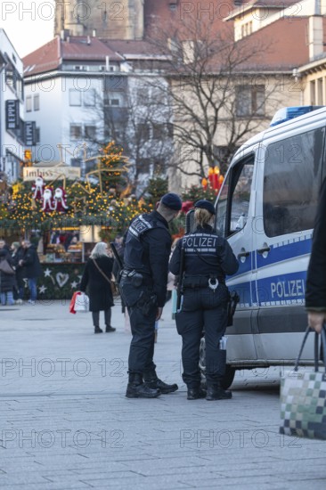 At the Christmas market in Stuttgart, the police are standing in front of the market hall with their car to ensure the safety of visitors. Your presence ensures a safe and peaceful celebration