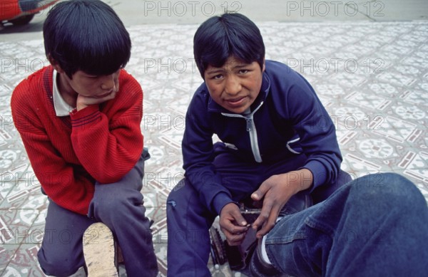 Teenager, young shoe cleaner at work, Puno on Lake Titicaca, Andean highlands, Peru, South America, September 1997, vintage, retro, old, historic