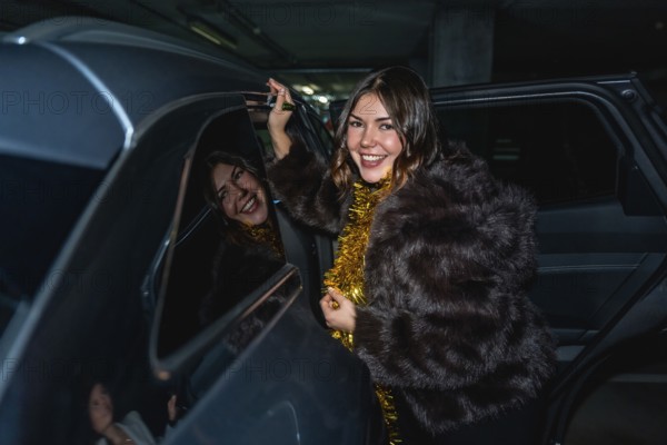 Young woman in a fur coat with gold tinsel smiles as she steps out of a car in a parking lot at night, ready for a stylish and festive new years eve celebration
