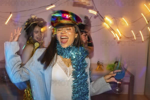 Three cheerful young women dancing and laughing together at a vibrant new year's eve or costume party, enjoying the festive atmosphere and colorful lights