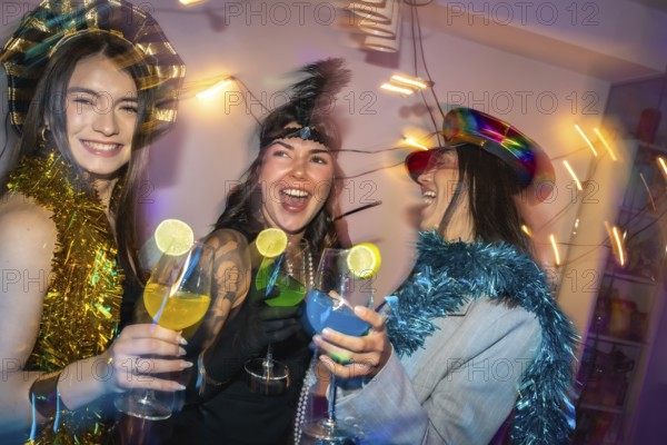 Diverse women in festive party hats and tinsel clink colorful lime garnished cocktails, laughing and dancing at a vibrant, energetic new years eve or costume party celebration