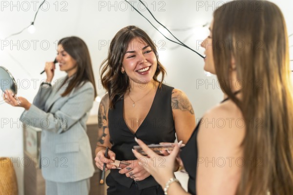 Young women friends applying makeup and styling hair, laughing and bonding as they get ready at home for a new years eve party, enjoying beauty, fun, and anticipation