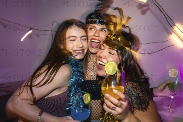 Three happy young women embracing, laughing and enjoying a festive celebration filled with cocktails and dress up, radiating friendship, fun, and connection under colorful party lights