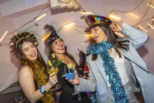 Three diverse young women happily celebrating and dancing together at a lively party, holding colorful cocktails, wearing festive costumes and tinsel decorations