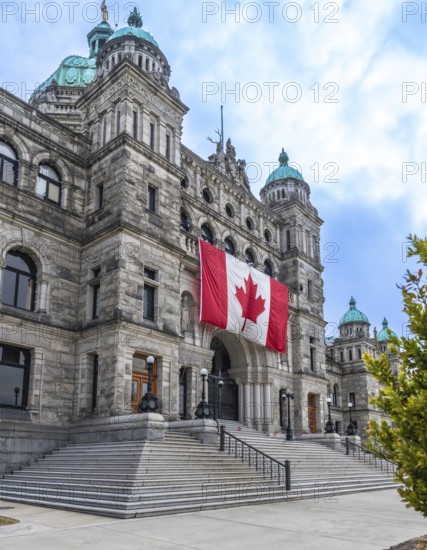 Parliament buildings in victoria, british columbia, proudly displaying a large canadian flag, symbolize the province's political heart and rich cultural heritage in the capital city