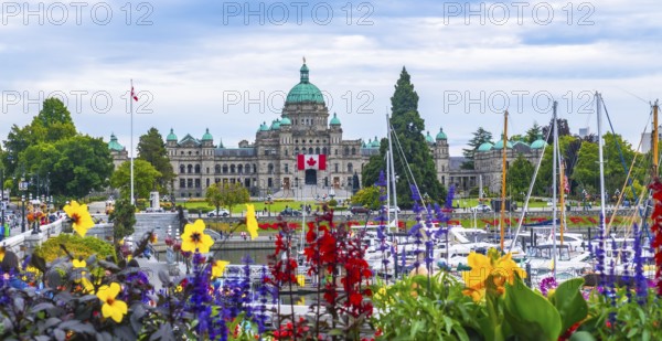 Colorful flowers decorate the inner harbour with the british columbia parliament buildings standing majestically on a sunny summer day in victoria, canada