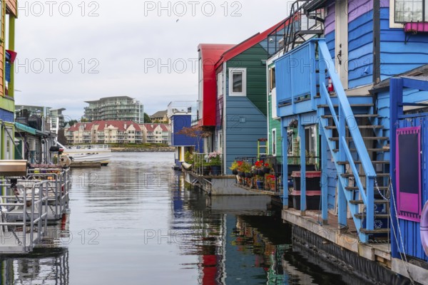 Fisherman's wharf park's vibrant floating homes create a picturesque scene, reflecting their bright colors on the calm water of victoria's inner harbour in british columbia, canada