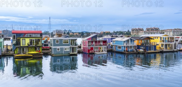 Fisherman's wharf park's vibrant houseboats create a picturesque scene, reflecting in the calm waters of victoria, british columbia, on a serene summer day