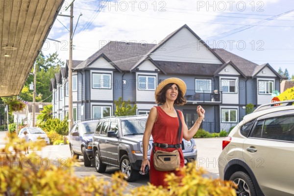 Happy female tourist strolling through chemainus, a charming town on vancouver island, british columbia, canada, savoring every moment of her summer vacation under the sunny sky