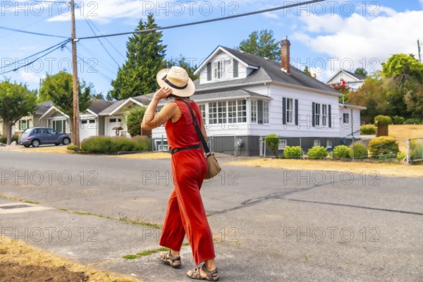 Tourist walking in a residential area of chemainus, a small town on vancouver island, british columbia, known for its outdoor murals and art galleries, during a sunny summer day