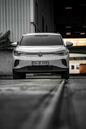 White car in an industrial environment on tracks, VW ID4 electric car, Deer Carsharing, Calw, Germany
