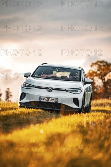 A white Volkswagen in a field at sunset, VW ID4 electric car, Deer Carsharing, Calw, Germany