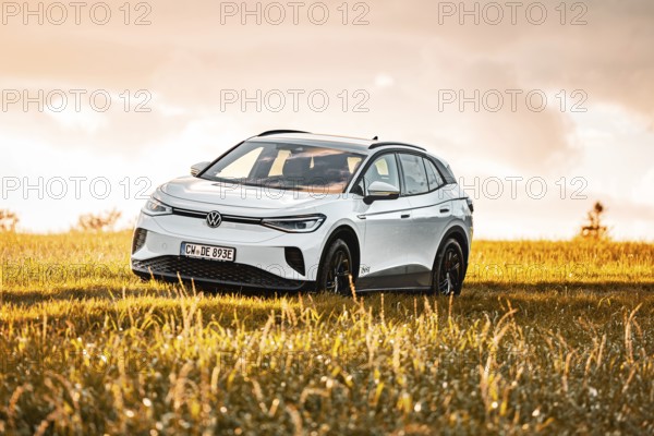 White car standing in a field at sunset, VW ID4 electric car, Deer Carsharing, Calw, Germany