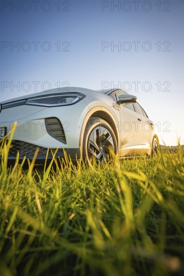 White car close-up on green field under clear sky, VW ID4 electric car, Deer car sharing, Calw, Germany