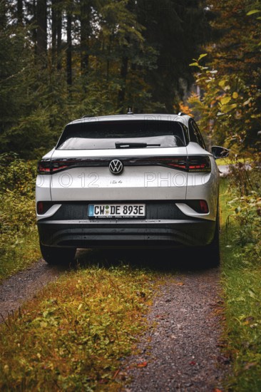Rear view of a white Volkswagen on a forest road, VW ID4 electric car, Deer Carsharing, Calw, Germany