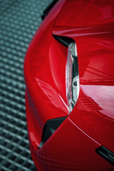 Close-up of the front end of a red Porsche with focus on headlight design, Porsche Taycan, Deer Carsharing, Calw, Germany