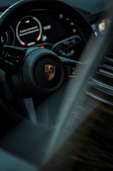 Close-up of a modern steering wheel with speedometer and LED indicators in a car, Porsche Taycan, Deer Carsharing, Calw, Germany