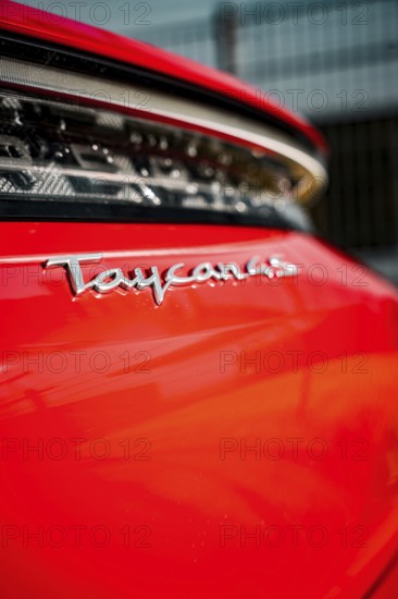 Close-up of Taycan lettering on a shiny red vehicle, Porsche Taycan, Deer Carsharing, Calw, Germany