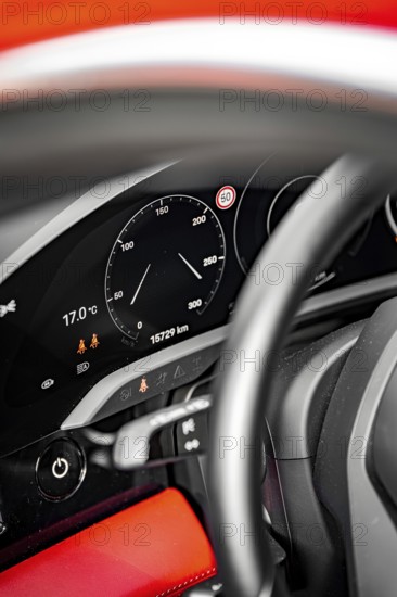 Detail of a dashboard with speedometer and steering wheel, accent color red, Porsche Taycan, Deer Carsharing, Calw, Germany