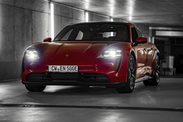 Red Porsche Taycan in underground car park at night with bright headlights and urban look, Porsche Taycan, Deer Carsharing, Calw, Germany