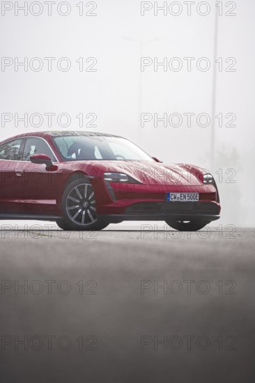Red vehicle on a road with fog background, Porsche Taycan, Deer Carsharing, Calw, Germany
