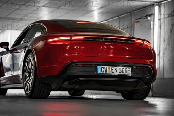 Red car in an underground garage, modern lighting, sporty rear, Porsche Taycan, Deer Carsharing, Calw, Germany