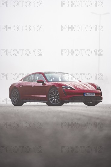 Red car parked on a road in a foggy environment, Porsche Taycan, Deer Carsharing, Calw, Germany