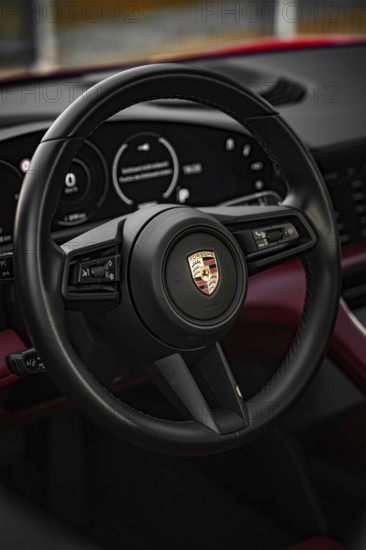 Black steering wheel in the luxurious interior of a Porsche, Porsche Taycan, Deer Carsharing. Calw, Germany