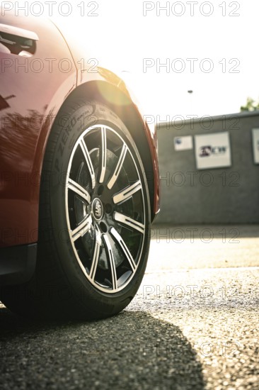 Close-up of a car tire on asphalt in sunlight, Porsche Taycan, deer car sharing. Calw, Germany