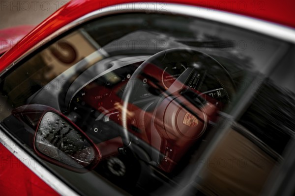 Reflected car interior with sporty design steering wheel, Porsche Taycan, Deer car sharing. Calw, Germany