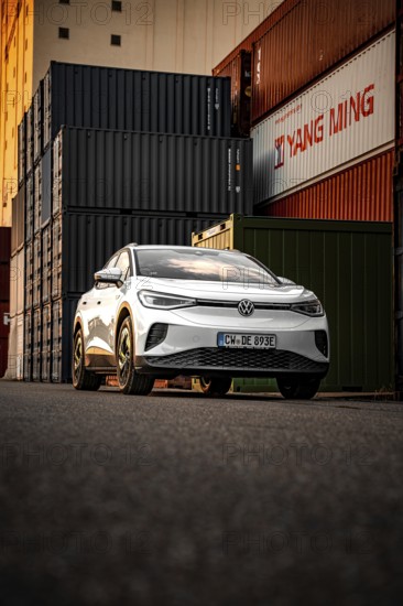 Silver car in front of high-stacked containers, VW ID4 electric car, Deer Carsharing, Calw, Germany