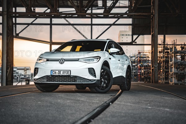 A car stands on rails in an industrial area at sunset, VW ID4 electric car, Deer Carsharing, Calw, Germany