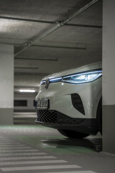 A car in an underground garage with headlights on at night, VW ID4 electric car, Deer Carsharing, Calw, Germany
