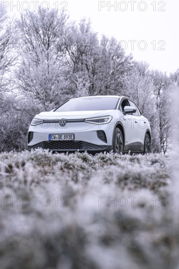 White car in frosty winter landscape with trees covered in hoarfrost, VW ID4 electric car, deer car sharing, Calw, Germany