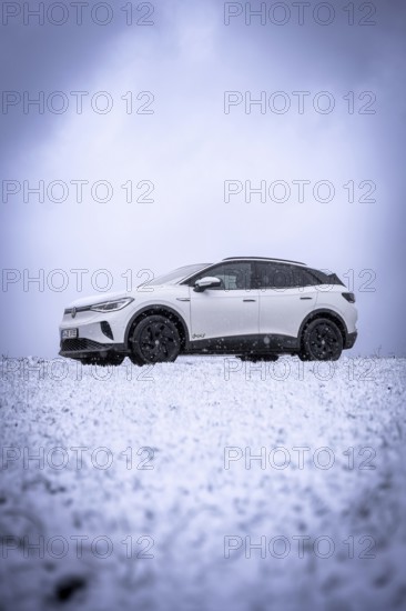 White car on snowy field under cloudy sky, VW ID4 electric car, Deer Carsharing, Calw, Germany