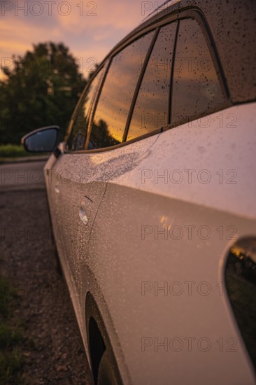 A car in the rain at sunset, reflected on wet windows, VW ID4 electric car, Deer Carsharing, Calw, Germany