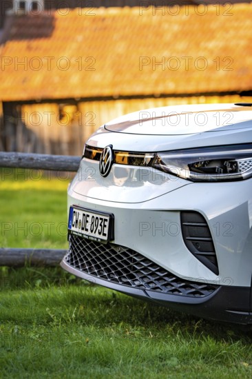 Close-up of a white car in front of a barn at sunset, VW ID4 electric car, Deer Carsharing, Calw, Germany