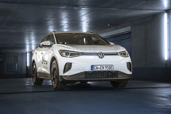 White car in a modern, illuminated underground car park with urban flair, VW ID4 electric car, Deer Carsharing, Calw, Germany