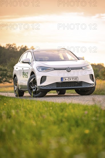 A car on a dirt road at sunset with a colorful sky, VW ID4 electric car, Deer Carsharing, Calw, Germany