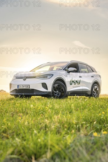 A car is standing in a meadow under a clear sky at sunrise, VW ID4 electric car, Deer Carsharing, Calw, Germany