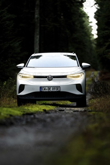 Front view of a car on a dark forest road, VW ID4 electric car, Deer Carsharing, Calw, Germany