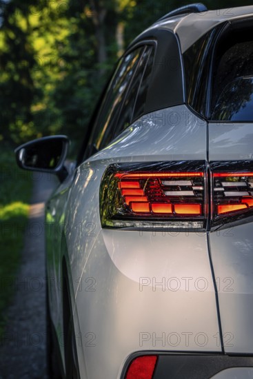Back view of a car in the woods on a small path, VW ID4 electric car, Deer Carsharing, Calw, Germany